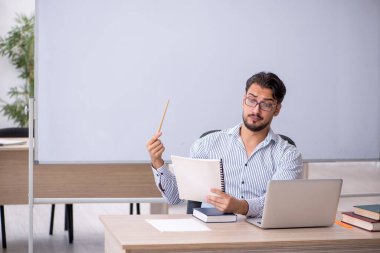 Sınıftaki genç erkek öğretmen.