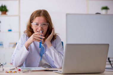 Laboratuarda çalışan genç bir kadın kimyager.