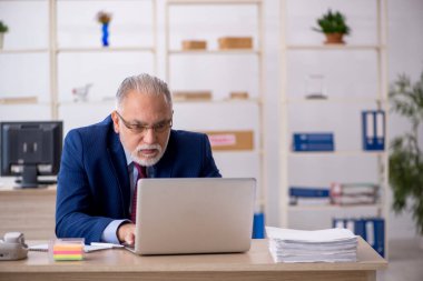 Ofiste çalışan yaşlı bir erkek.