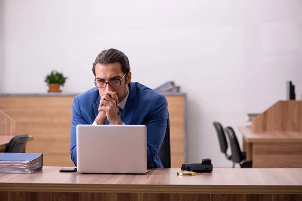 Empleado joven sentado en el lugar de trabajo — Foto de Stock