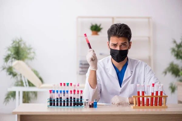 Νεαρός βιοχημικός άντρας που δοκιμάζει δείγματα αίματος σε πανδημία — Φωτογραφία Αρχείου