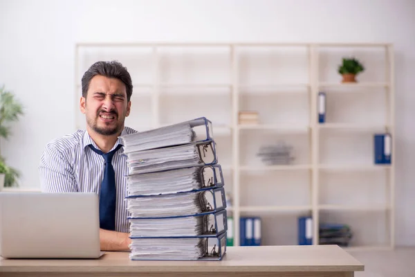 Joven empleado masculino y demasiado trabajo en la oficina —  Fotos de Stock