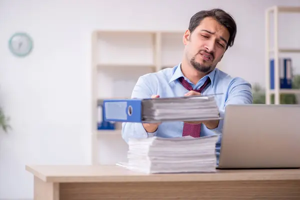 Jeune employé masculin et trop de travail au bureau — Photo