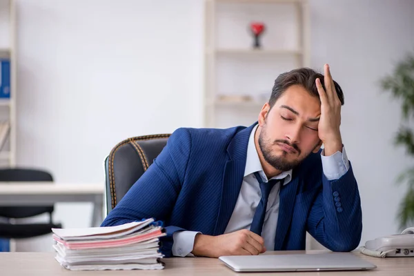 Mladý muž zaměstnanec extrémně unavený v kanceláři — Stock fotografie