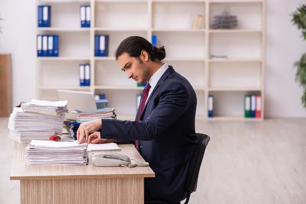 Joven empleado masculino infeliz con el trabajo excesivo —  Fotos de Stock