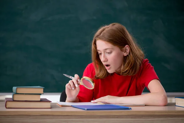 Jonge vrouwelijke student bereidt zich voor op examens in de klas — Stockfoto