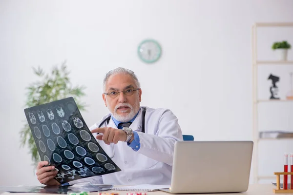 Gammal manlig röntgenläkare som arbetar på kliniken — Stockfoto