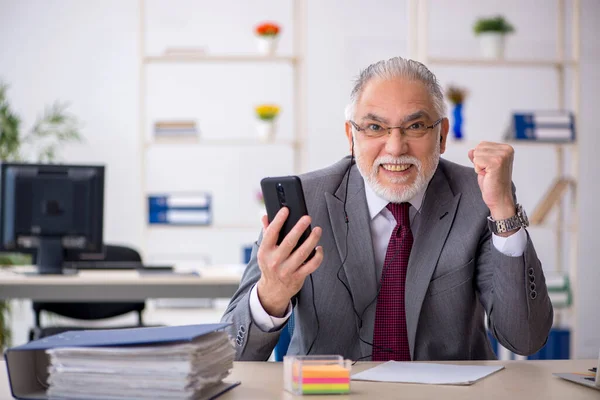 Homem velho empregado sentado no escritório — Fotografia de Stock