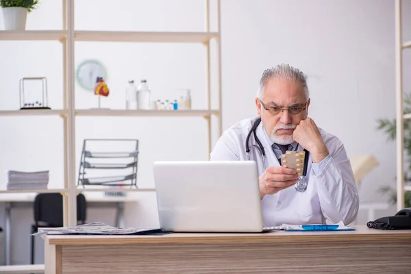 Gammal manlig läkare som arbetar på kliniken — Stockfoto