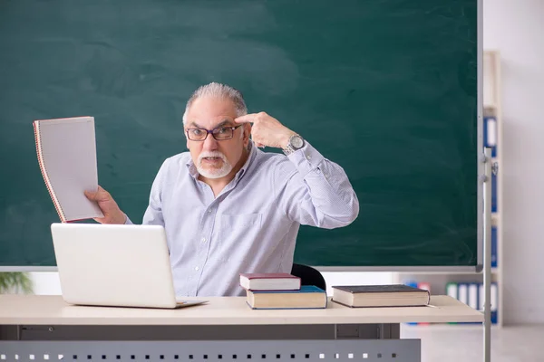 Viejo profesor delante del tablero verde — Foto de Stock