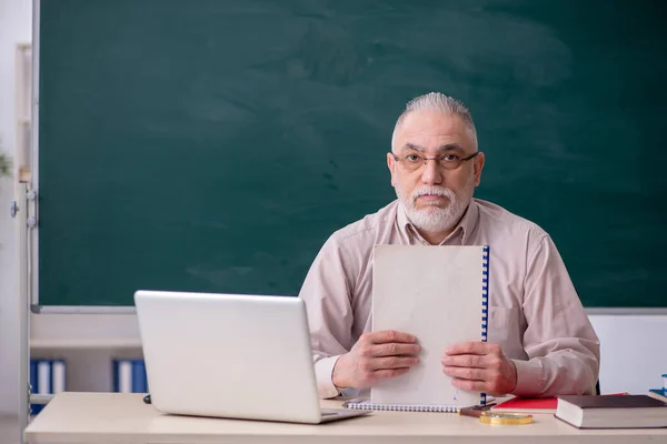 Old male teacher in front of blackboard — Stock Photo, Image