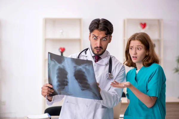 Ung manlig läkare radiolog och kvinnlig assistent arbetar i th — Stockfoto