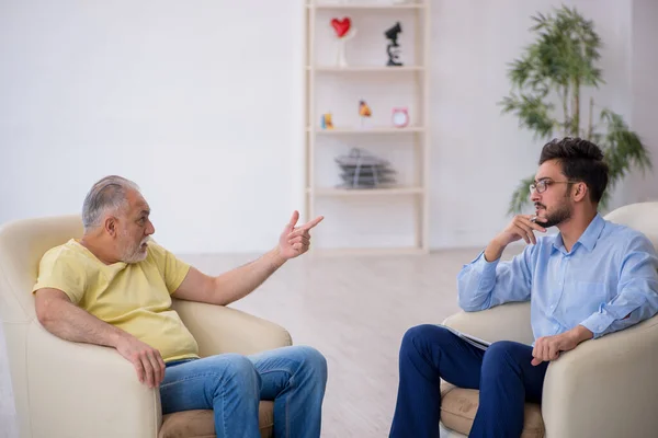 Old man visiting young male psychotherapist — Stock Photo, Image