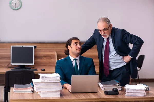Velho empregador masculino e jovem assistente no conceito de bullying — Fotografia de Stock