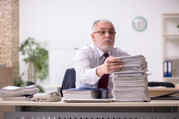 Employé masculin âgé et trop de travail sur le lieu de travail — Photo