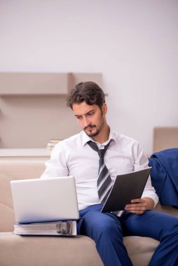 Genç erkek çalışan salgın sırasında evden çalışıyor.