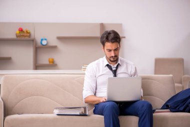 Genç erkek çalışan salgın sırasında evden çalışıyor.