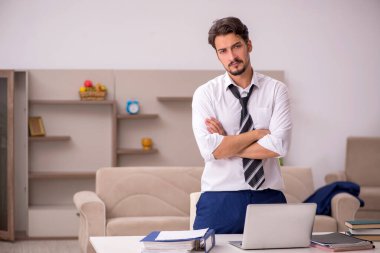 Genç erkek çalışan salgın sırasında evden çalışıyor.