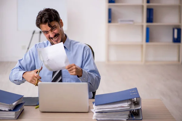 Joven empleado masculino descontento con el trabajo excesivo en la oficina —  Fotos de Stock