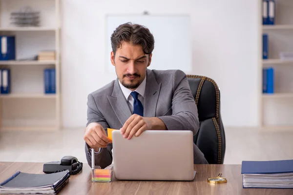 Jeune employé masculin assis dans le bureau — Photo