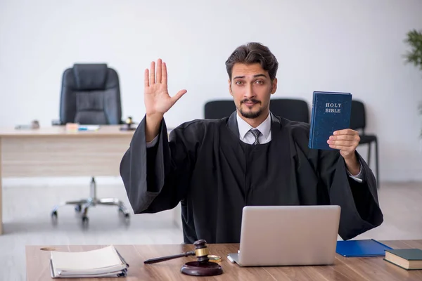 Young male judge taking oath on holly bible — Stock Photo, Image
