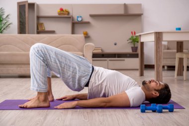 Genç adam evde spor yapıyor.