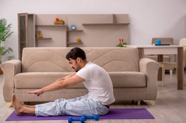 Genç adam evde spor yapıyor.