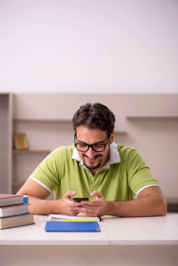 Evde okuyan genç bir erkek öğrenci.