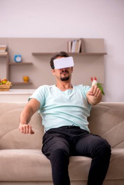 Evde sanal gözlük takan genç bir öğrenci.
