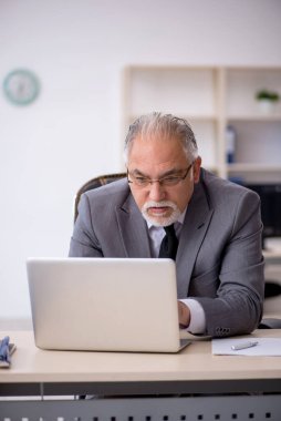 Ofiste çalışan yaşlı bir erkek.