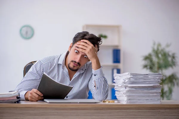 Jovem funcionário masculino infeliz com excesso de trabalho no escritório — Fotografia de Stock