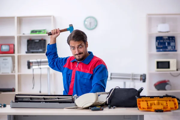 Jovem reparador do sexo masculino reparando ar-condicionado — Fotografia de Stock