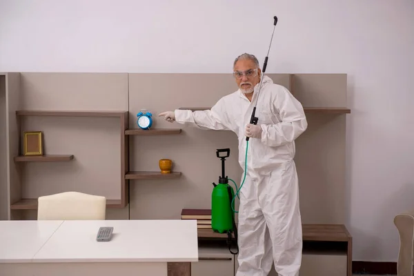 Viejo contratista masculino haciendo control de plagas en casa —  Fotos de Stock