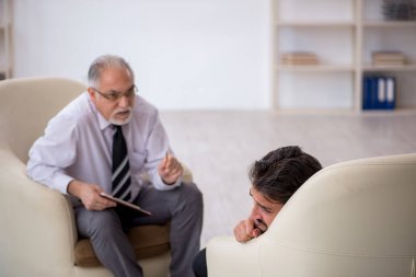 Genç adam yaşlı psikoloğu ziyaret ediyor.