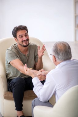 Genç adam yaşlı psikoloğu ziyaret ediyor.