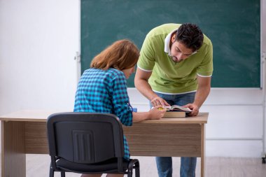 Genç öğretmen ve öğrenci sınıfta.