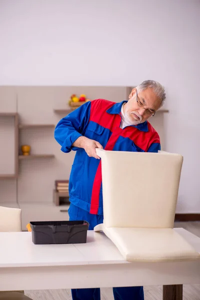 Alter Tischler repariert Stuhl im Haus — Stockfoto