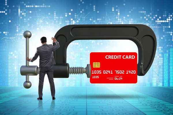 Concept of credit card debt with clamp and businessman — Stockfoto