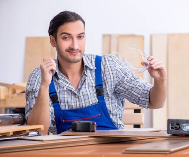 Genç erkek marangoz içeride çalışıyor.