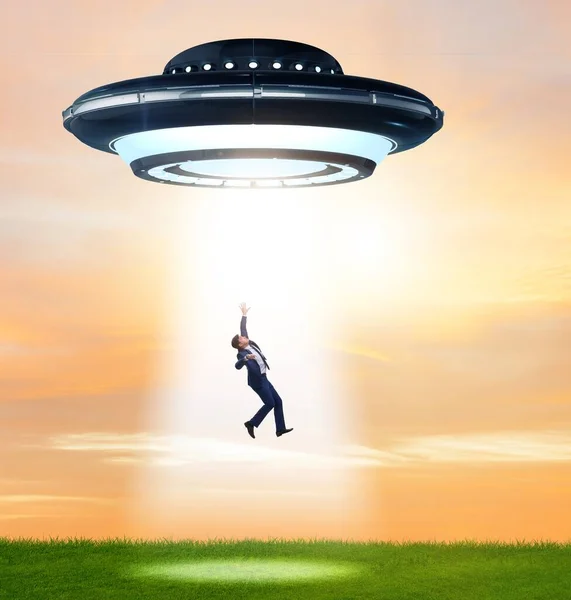 The flying saucer abducting young businessman — Stock Photo, Image