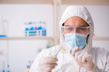 Genç erkek kimyager zoolog salgın sırasında laboratuvarda çalışıyor.