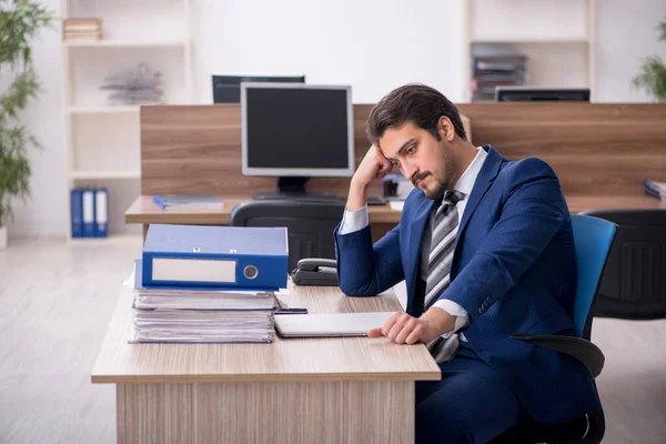Fiatal férfi alkalmazott és túl sok munka az irodában. — Stock Fotó