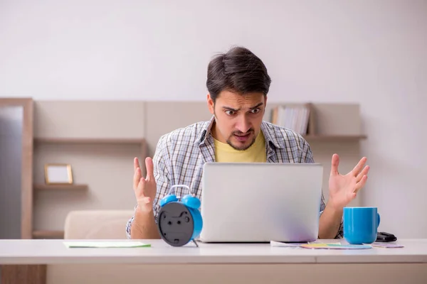 Joven freelancer masculino en concepto de gestión del tiempo en casa —  Fotos de Stock