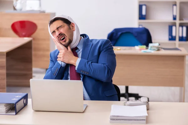 Mladý muž zaměstnanec trpí bolestí zubů na pracovišti — Stock fotografie