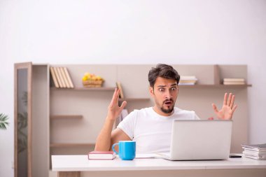 Genç erkek çalışan salgın sırasında evden çalışıyor.