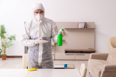 Genç erkek müteahhit evde haşere kontrolü yapıyor.