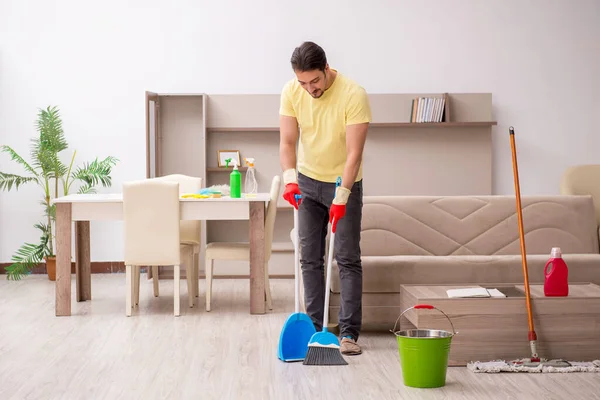 Joven contratista masculino limpiando la casa — Foto de Stock