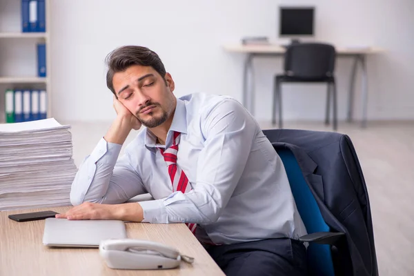 Junge männliche Mitarbeiter sitzen am Arbeitsplatz — Stockfoto