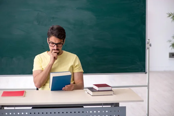 Mladý muž student před tabulí — Stock fotografie