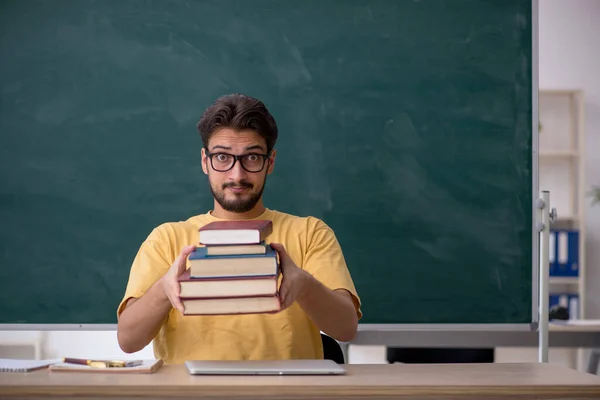 Jonge mannelijke student bereidt zich voor op examens in de klas — Stockfoto